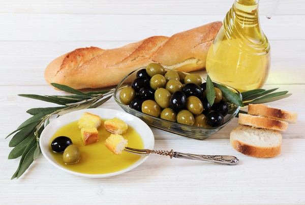 Olives, olive oil and bread on the wooden table